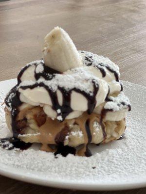 Liege Waffle with bananas, Peanut butter, chocolate drizzle, powdered sugar, and fresh whipped cream