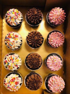 Chocolate cupcakes with vanilla, chocolate, and strawberry frostings.