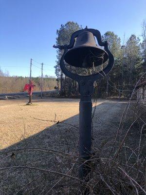 Bell and cross on side yard of the church.