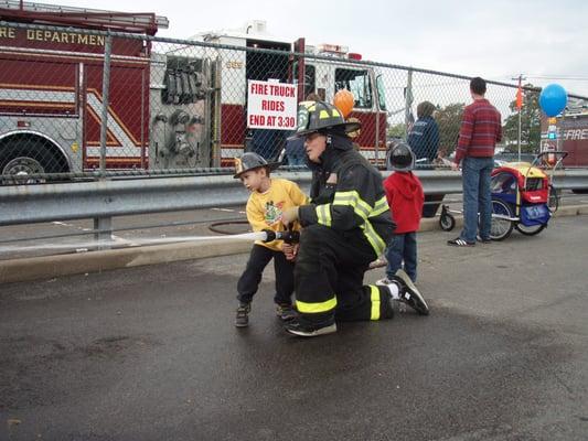 Kid learning how to handle the firehose @ Fire Prevention day