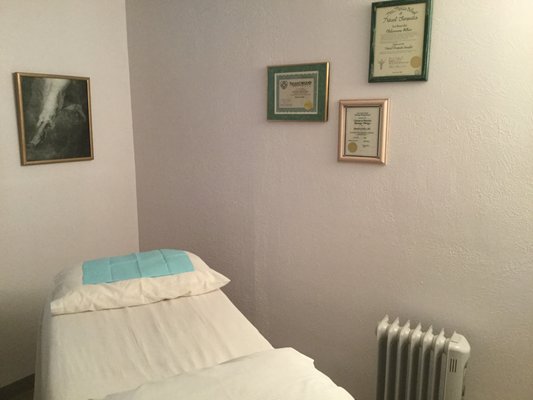 Interior acupuncture & Chinese Massage table & room. Board certifications on the wall.