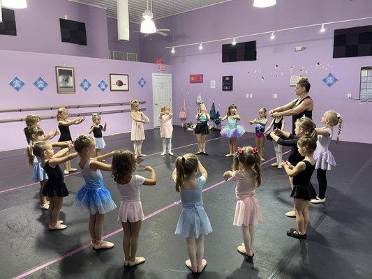 Learning first position port de bra in ballet class.