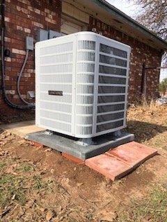 New Heat pump note the feet under it plus the pad, and the red bricks to prevent water from staying around unit and making ice in winter.