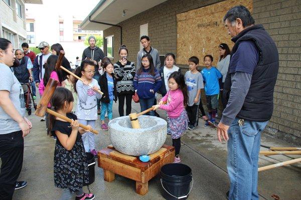 Kids learn how to make mochi using a mochitsuki for new years!