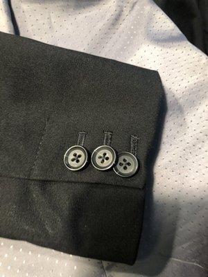 Buttons are way too close together, overlapping, and the sleeve is sewed shut