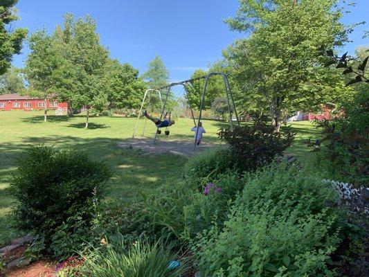 Camp Hollis main building In distance and swings near memory garden