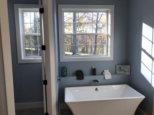 Separate toilet room and tub area with heated tile floors