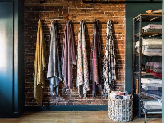 Lambswool soft and cozy throws line exposed brick wall of the second-oldest building in Portland Maine, Evangeline Linens