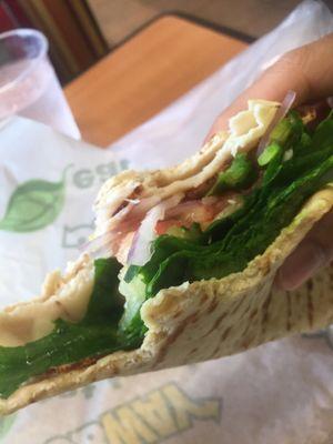 wheat flatbread with turkey, provolone cheese, spinach, tomatoes, red onions, cucumbers, green peppers, and oil and vinegar