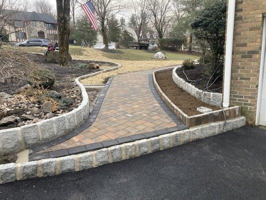 New paver sidewalk complete with granite edging around flowerbeds