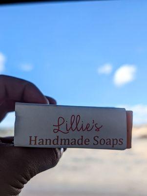 The side of Lillie's Handmade Soaps' bar soap, which bears the shop's logo, ft. New Mexico scenery & cornflower sky in the background