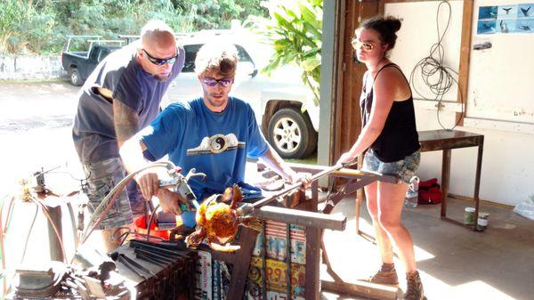 Master glassblower Evan Schauss being assisted by Tasha and Scott creating his signature hand blown glass turtle