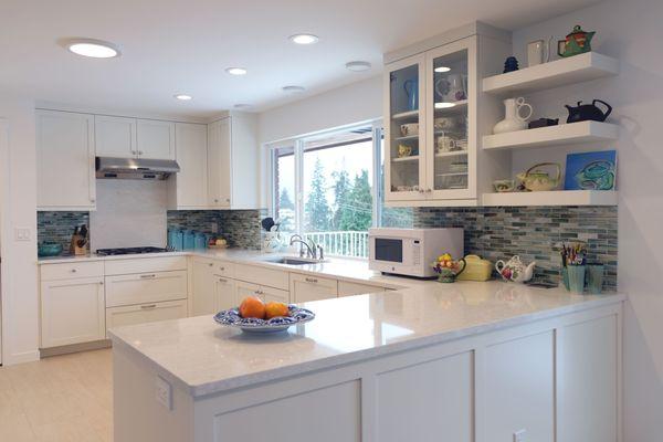 Remodeled kitchen with Canyon Creek cabinets, recycled glass tile backsplash, and quartz on the countertop and behind the range.