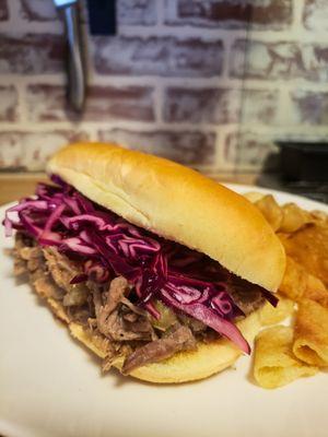 A tender, juicy carnitas-style pulled-pork sandwich makes for a great center piece to a party for friends to enjoy!