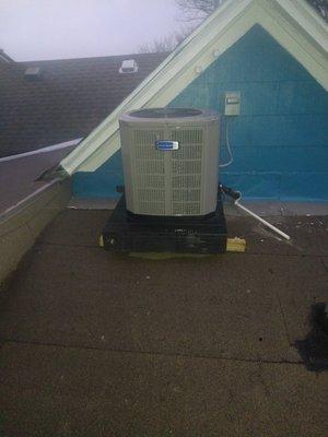 Per customer request new AC condenser installation in progress on roof of home