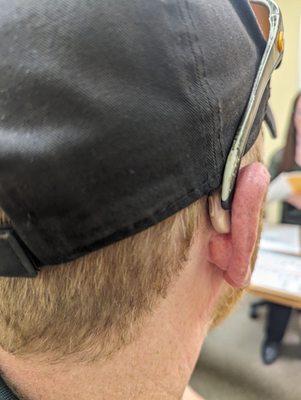 Looking at how the beige hearing aids look from the back of his head. Right side