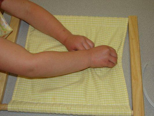 Child working with dressing frame.