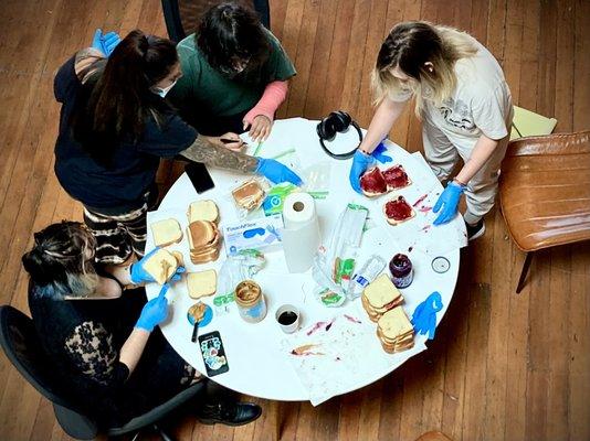 Peer teaches the mental health benefits of helping others.Clients volunteered to make sandwiches for homeless men & women in the community.