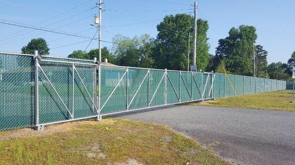 6 ft. Commercial chain-link fence and gates with green vinyl privacy slat inserts. Call us for your next fence installation!