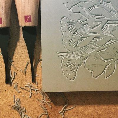 Linocut and tools used to carve away the parts that won't print when put on the press