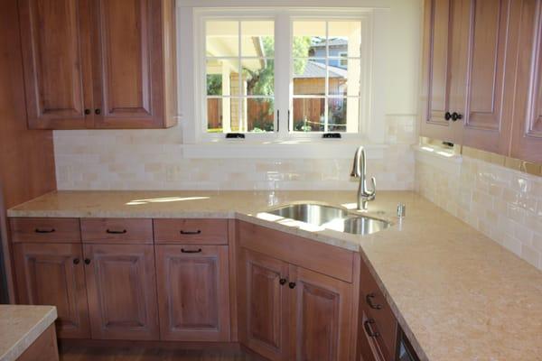 Leathered limestone slab counters with tile splash.