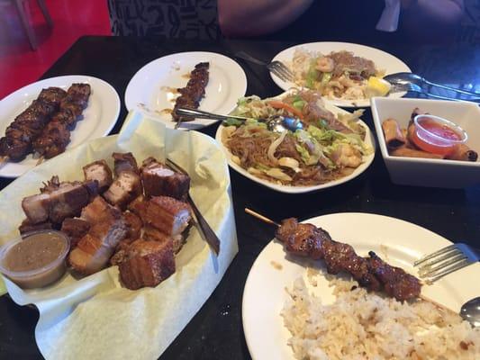 Lechon kawali, pancit bihon, chicken and pork bbq sticks, lumpias and garlic rice