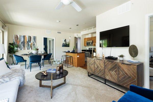 Living room with a view of the dining room and kitchen with white walls