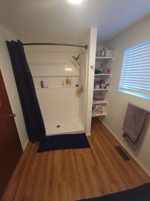 Bathroom created from laundry room by moving water heater and adding a shower, toilet, vanity, closet, flooring and paint.