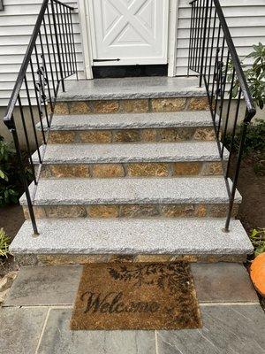 After picture of stairs with new salt and pepper granite cappings and landing area complete with a new veneer facing and sides