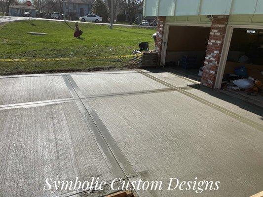 Concrete driveway replacement with a broomed finish and picture frame look.