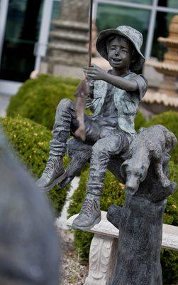 This is a bronze boy with Dog Fishing Statue