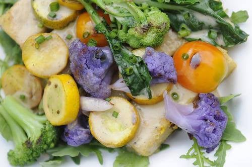 Roasted Corn Polenta topped with Veggie Melange on top of greens with Gravy.