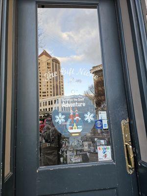 The main door and entrance to the Gift Niche. Reflecting one can see the Wells Fargo Bank building.