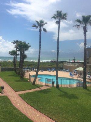 Balcony view of pool and path leads to beach