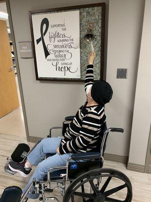 Mom signaling the bell signifying end of her chemo treatments.