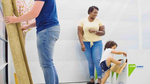 family moving belongings into storage unit at STORExpress