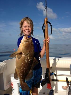 JC with a red grouper that he spearfish aboard Two Conchs while free diving on a lobster and Spearfishing charter.