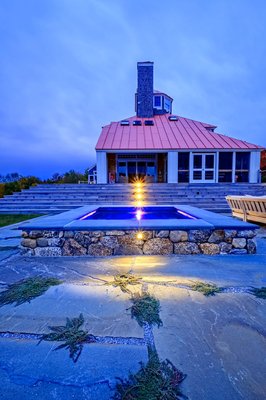 Fieldstone veneer surrounding hot tub with bluestone patio pavers.