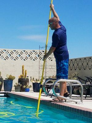 Pool technician Jessie Shipman, vacuuming a pool