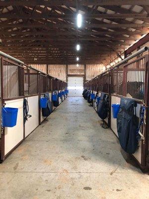 One isle of the show/training side of the barn. Isles are kept clean and clear- with blankets kept in stall bags or neatly hung. No clutter