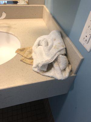 Soiled towels from the mess on the floor that were left on the counter.