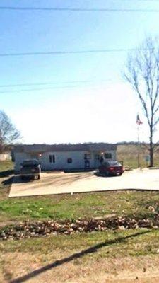 view of front of Crumrod post office building and parking lot