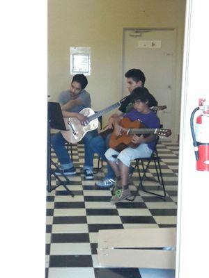 Guitar instructor with two young students, what I like classes are small you child gets allot of attention.