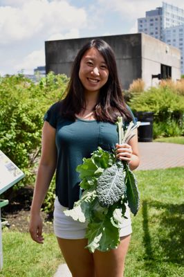 Participant in our Kendall Center corporate wellness program holding freshly harvested kale.