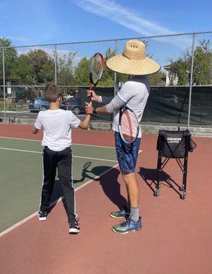 Coach Brandon helping change Stanley out of his eastern grip into a continental grip