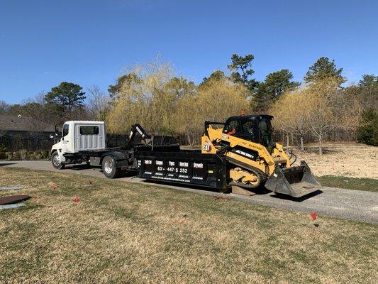 Roll off truck and track loader to grade out property after new tank installation