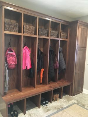 Walnut locker cabinetry, solid wood bench, crown moulding, and broom closet.