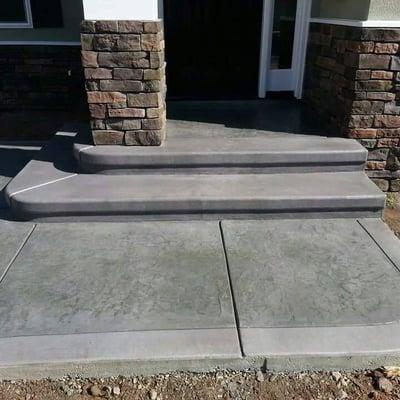 Steps with a broom finish border and roman slate stamp pattern in the fields.