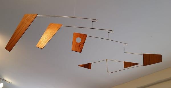 The Fuji" mobile is comprised of Mara wood and Brass armatures. Elegant with warm coloration for interior living spaces.