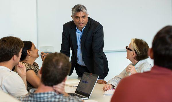 UT faculty member teaching a group of professionals